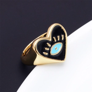 Adjustable gold heart ring with blue evil eye enamel design on black background