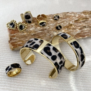 7-piece gold leopard print jewelry set with cuff bracelets and rings on wooden stand