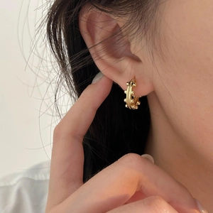 Minimalist 925 sterling silver hoop earrings with gold bead design worn by a woman