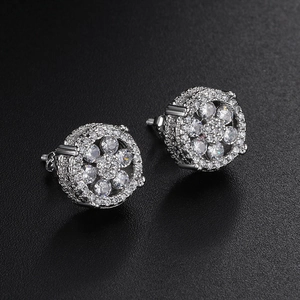 Macro view of iced out round stud earrings with pave zircon and screw back closure