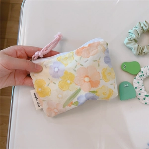 Close-up of mini floral cotton pouch with zipper and simple wish label