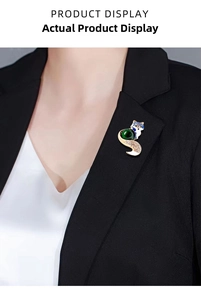 Close-up of vintage fox brooch with green gemstone and blue enamel on a black blazer