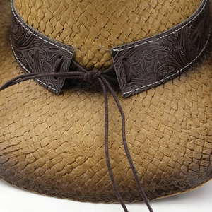 Detailed close-up of high-density straw weave and floral embossed leather hatband