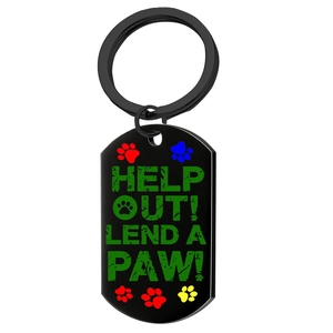 Detailed macro view of black metal dog tag featuring a green paw print and artistic text