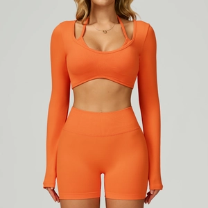 Detail view of orange seamless yoga set with layered long-sleeve crop top and shorts