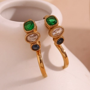 Macro shot of 18K gold plated earrings featuring green, white and blue gemstones
