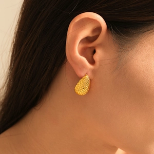 Water-drop earrings with grid pattern in 18k gold-plated copper on a female model