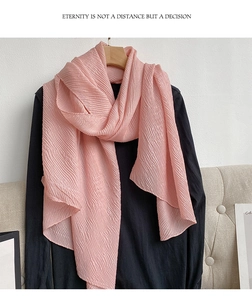 Dettaglio della sciarpa in chiffon plissettato rosa chiaro con trama di seta lucida
