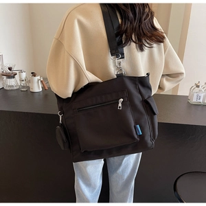 Detail of large capacity black oxford tote bag with crossbody strap and small round coin purse