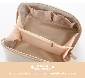 Macro view of creamy beige PU makeup bag interior with layered compartments and zipper pocket