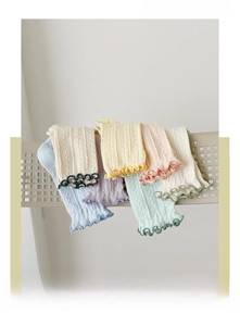 Detail of pastel cotton crew socks with cable knit texture and ruffled trim edges
