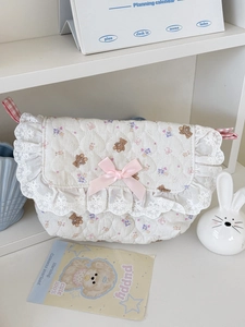 Détail de pochette matelassée à fleurs et ours avec dentelle et nœud rose