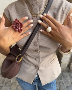 Primo piano di un set di gioielli alla moda con anello a fiore in resina e collana d'oro