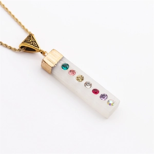 Gold pendant necklace with white crystal and seven colorful rhinestones on white background