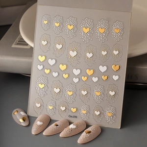 Detail of Co-270 nail stickers with gold heart patterns and pearl dots on grey background