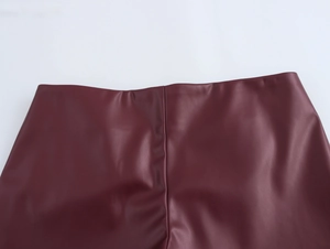Detail view of burgundy faux leather fabric showing high-quality stitching and texture