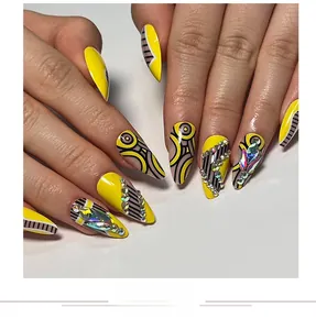 Macro detail of long stiletto nails with lemon yellow base, black stripes and sparkling rhinestones