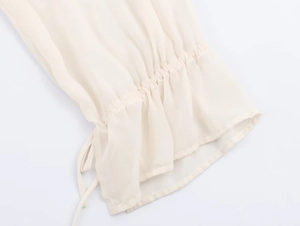 Close-up of elastic drawstring cuffs with ruffled edges on a beige georgette blouse