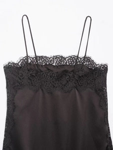 Détail du tissu en satin noir et de la dentelle délicate sur ce haut à fines bretelles