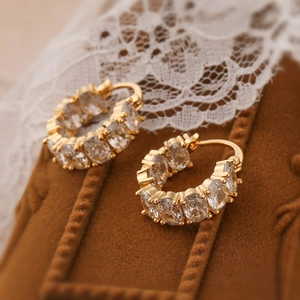 Exquisite 18K gold plated geometric hoop earrings with sparkling zircon stones on brown velvet