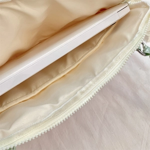Detail of laptop sleeve interior showing main compartment with laptop inside and metal zipper