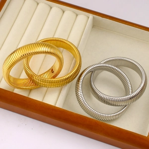 Macro view of gold and silver plated flexible snake scale textured bracelets in a display box