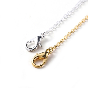 Macro shot of gold and silver lobster clasps with O-shaped chain connectors for jewelry