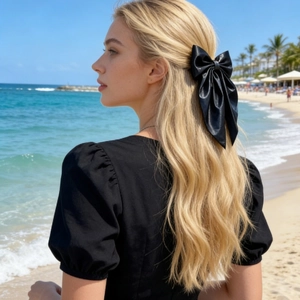 Elegant large black bow hair clip with long ribbons worn in a half-up hairstyle