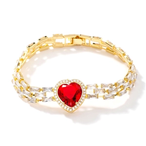 Luxury gold bracelet featuring a large red heart-shaped gemstone and cubic zirconia