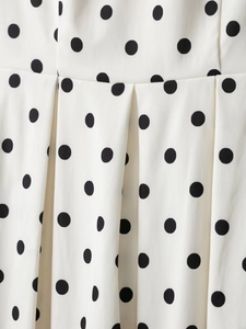 Détail du tissu à pois blancs avec texture plissée et design de taille élastique