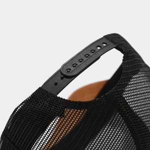 Close-up of black breathable mesh trucker hat with adjustable plastic snapback closure