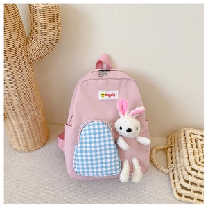 Close-up of pink kids backpack with blue checkered pocket and plush bunny decoration