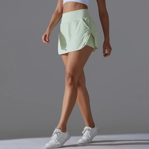 Detail view of high waisted mint green tennis skirt with side pockets and built-in shorts