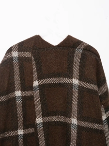 Detail of brown plaid knitted jacket fabric showing soft texture and checkered pattern