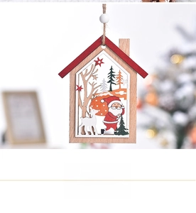 Détail d'un ornement de maison en bois découpé au laser avec Père Noël et petit renne