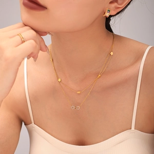 Collier double épaisseur doré avec pendentif infini serti de zircons et trèfle