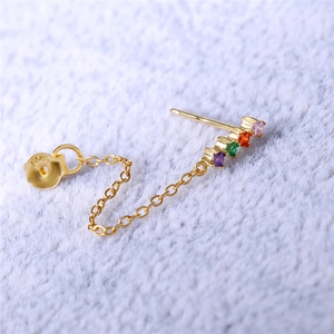 Close-up of S925 sterling silver hallmark on gold chain earrings with rainbow gemstones