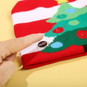 Knitted Christmas hat with LED lights and Santa pattern shown with the power button