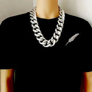 Grote grove zilveren ketting met veren broche op een zwart effen t-shirt
