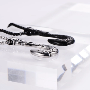 Polished silver and black Maui fish hook pendants with intricate tribal carvings