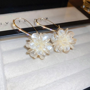 Détail macro de boucles d'oreilles fleurs vintage avec perles et crochets dorés
