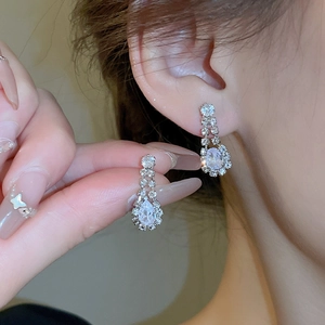 Detailed view of luxury silver water drop earrings with sparkling clear crystals