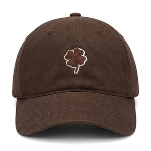 Detailed close-up of clover embroidery on dark brown cotton twill baseball cap
