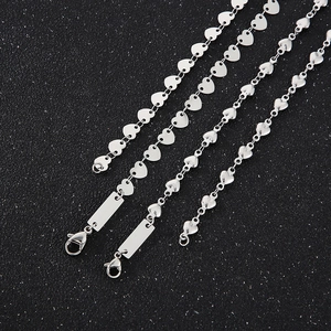 Polished stainless steel heart link necklaces and square pendants on black background
