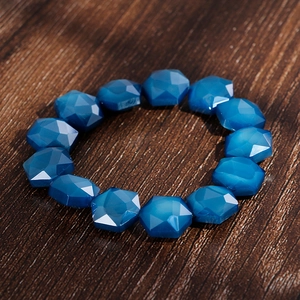 Detailed close-up of blue faceted crystal beads bracelet on rustic wood background