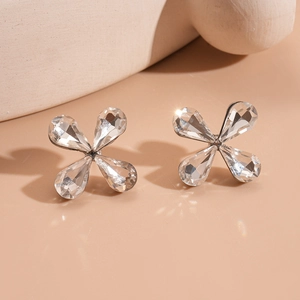 Close-up of sparkling glass flower stud earrings with clear teardrop petals on silver base