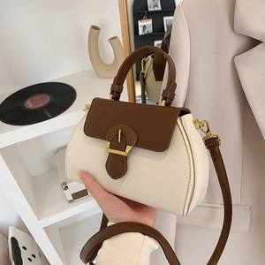 Detail of vintage bicolor handbag featuring white pebble leather and gold buckle