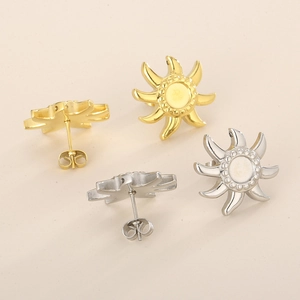Dettaglio di orecchini a forma di sole in acciaio inossidabile oro e argento con intarsio