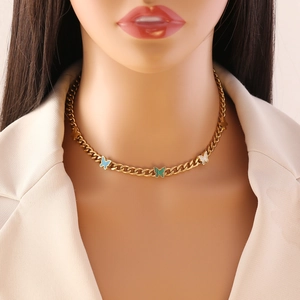 Detail of gold chain necklace featuring colorful butterfly pendants on a model