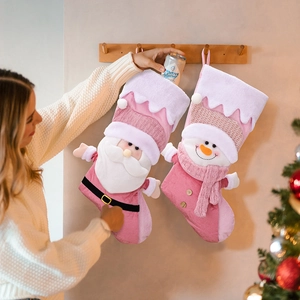Pink and white Nordic Christmas stockings with Santa and Snowman plush holiday designs